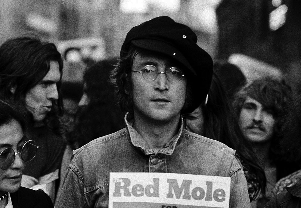 John Lennon demonstrating with a copy of Red Mole